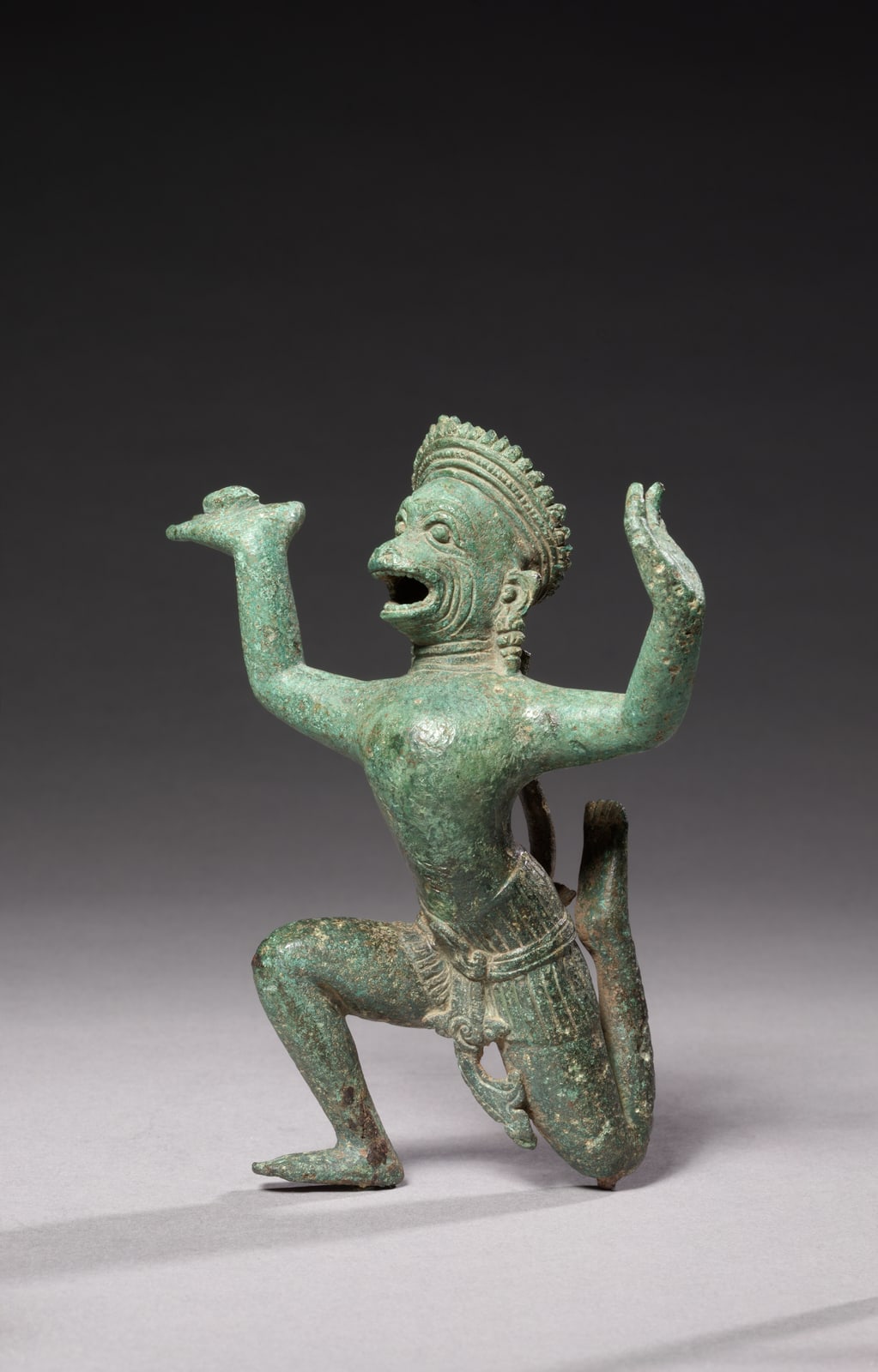 A small Khmer bronze of Hanuman flying with one arm raised and a bent leg