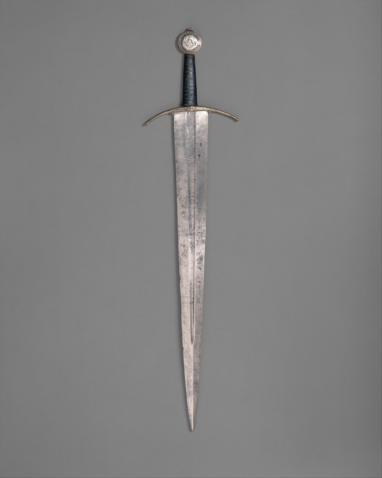 Historical European steel sword with a crossguard, shown as a contextual museum object